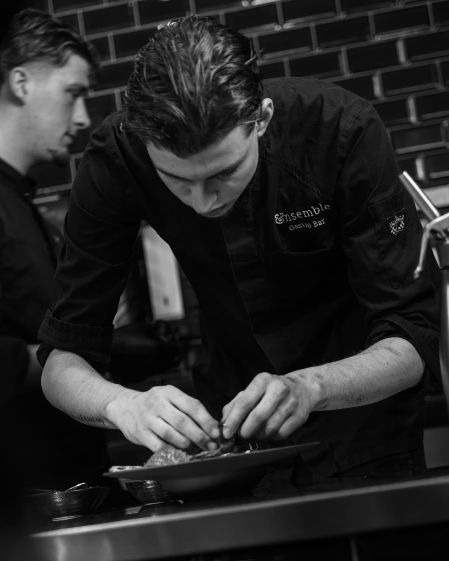 Kok van Ensemble Gastro & Bar in Zwolle dresseert een deelgerecht in de keuken